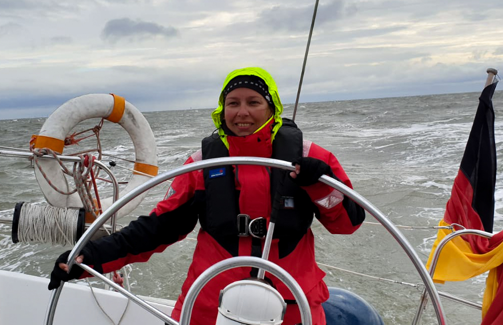 woman on sailboat steering wheel
