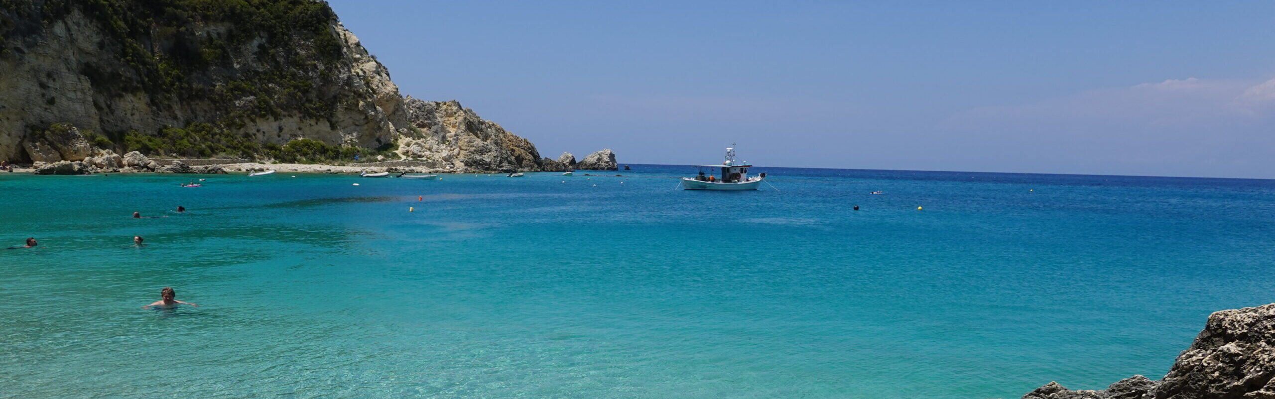 crowded beach with fishing boat