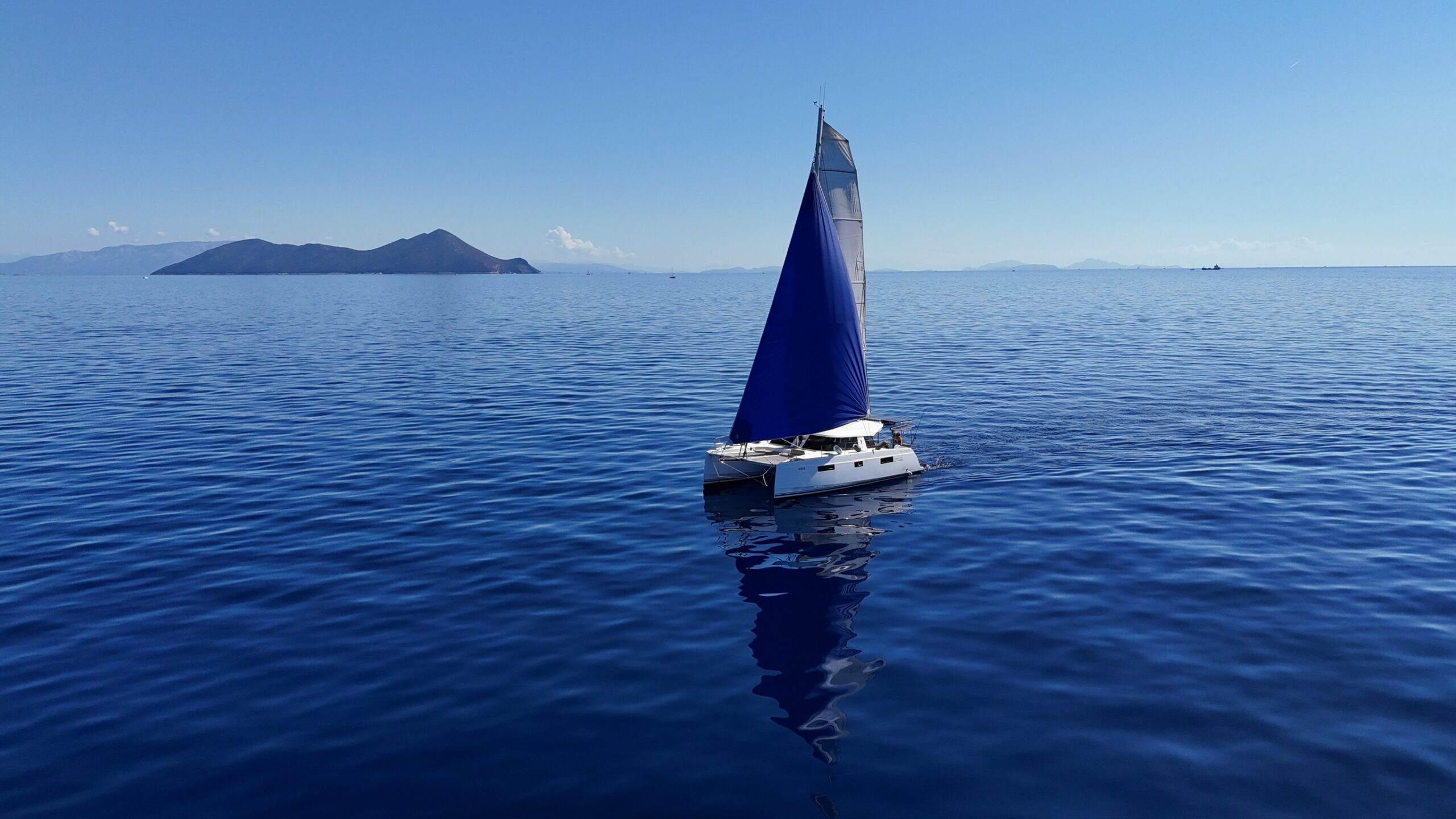catamaran under sail on calm water