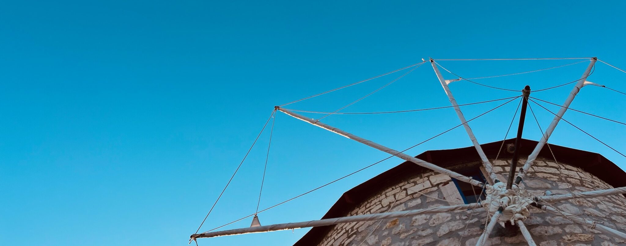 defunct windmill from below with blue sky