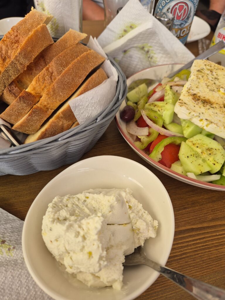 bread, greek salad and dip on bowls on a table